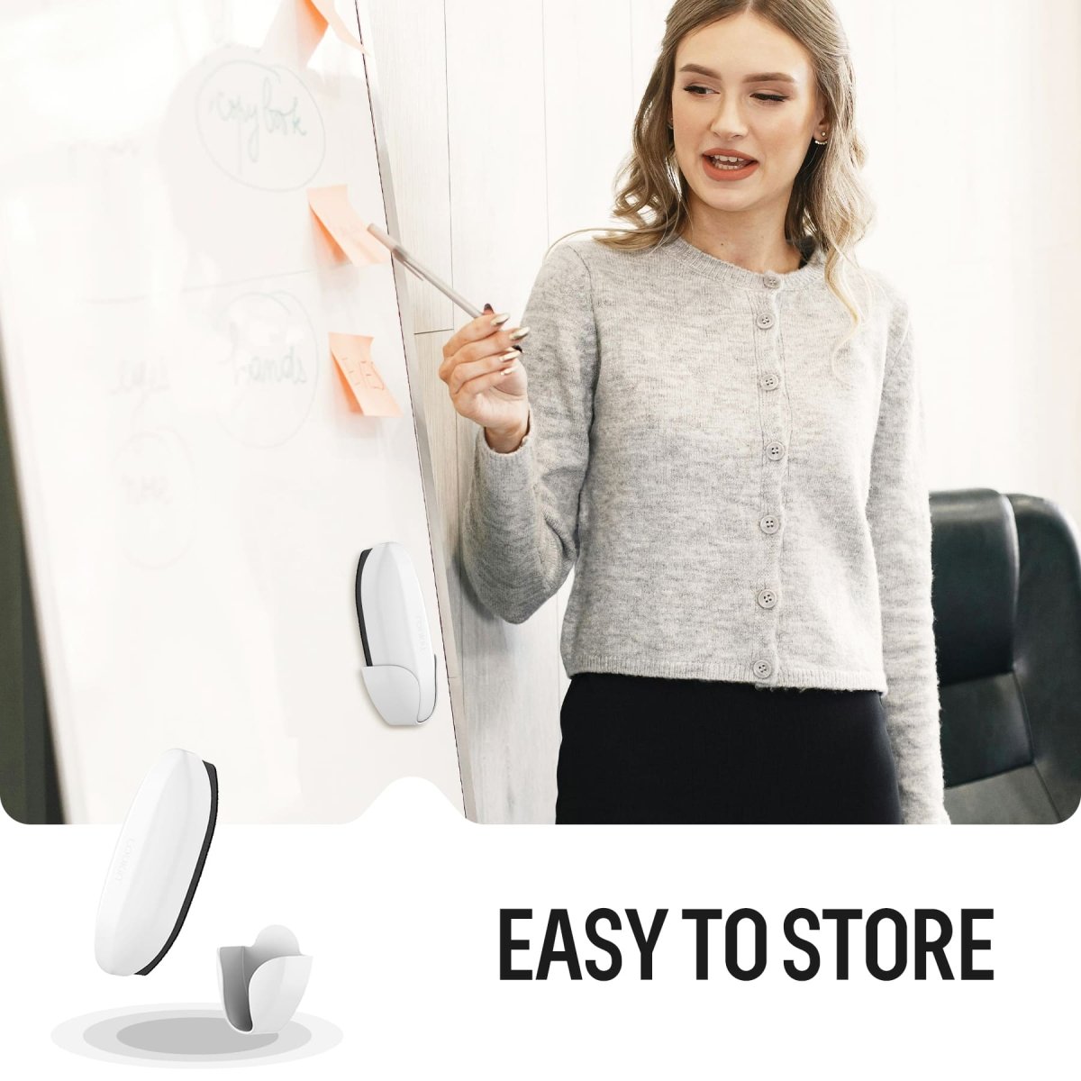 A professional woman in a gray cardigan is pointing to notes and sticky flags on a whiteboard. The white loukin Double-Sided Whiteboard Eraser is shown being stored EASY TO STORE with its magnetic holder on the board's surface, demonstrating convenient, clutter-free storage.