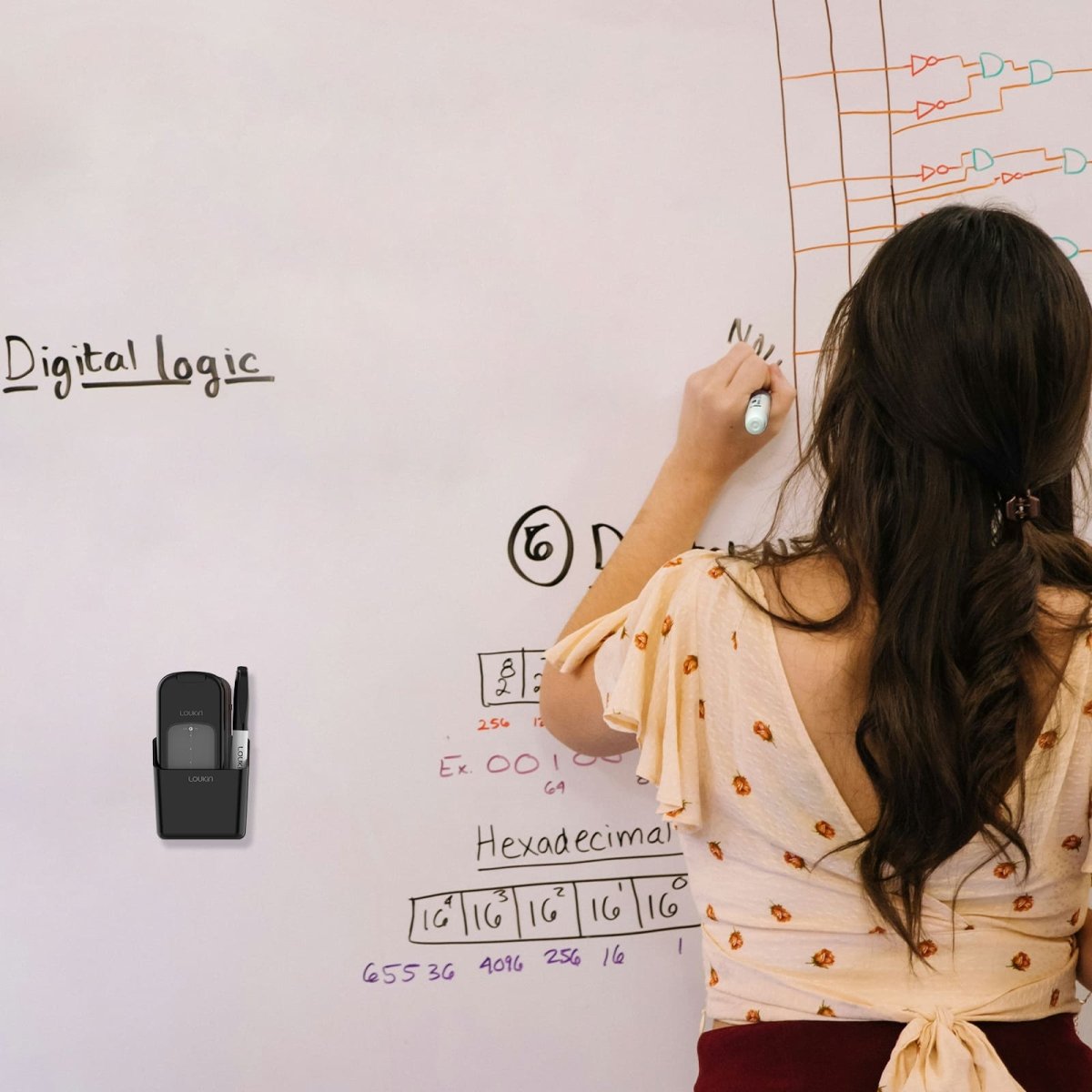 A young woman is writing a digital logic diagram (including "Digital logic" and "Hexadecimal" notes) on a large white classroom or office whiteboard. The black loukin All-in-One Eraser (W3543K) is magnetically attached to the board on the left, holding a dry-erase marker, demonstrating convenient storage during use.