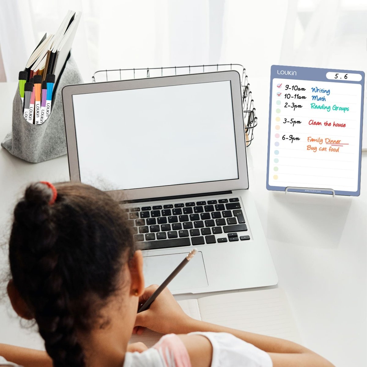 A lifestyle image showing a student using the LOUKIN **Dry Erase Checklist** (model W1308K) for task organization while studying at a desk. The checklist is displayed next to a laptop and contains a written daily schedule with tasks like "Writing," "Math," and "Clean the house," highlighting its use for **student and home task management**.