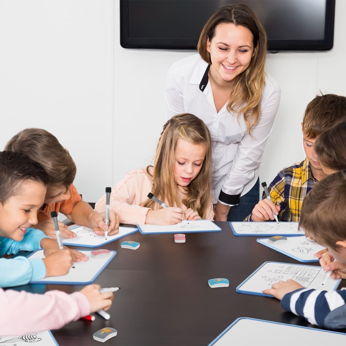 A product image showing a group of children, including a girl and a boy, using the LOUKIN Kids Dry Erase Erasers, model W3507, on individual whiteboards in a classroom setting with a female teacher supervising. The erasers feature cartoon animal designs.