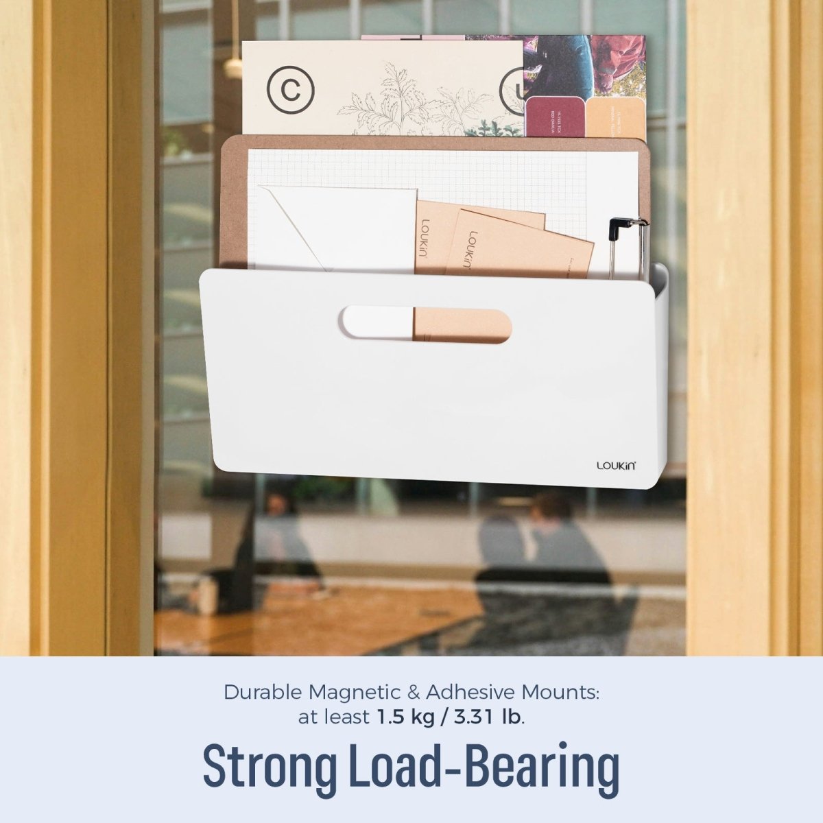 Loukin Magnetic File Holder (S1301) in white, highlighting its Strong Load-Bearing capability of at least 1.5 kg / 3.31 lb using Durable Magnetic & Adhesive Mounts. The holder is shown attached to a glass surface (likely a window or glass door in an office setting), filled with documents, a clipboard, and small envelopes, demonstrating its robust storage capacity.