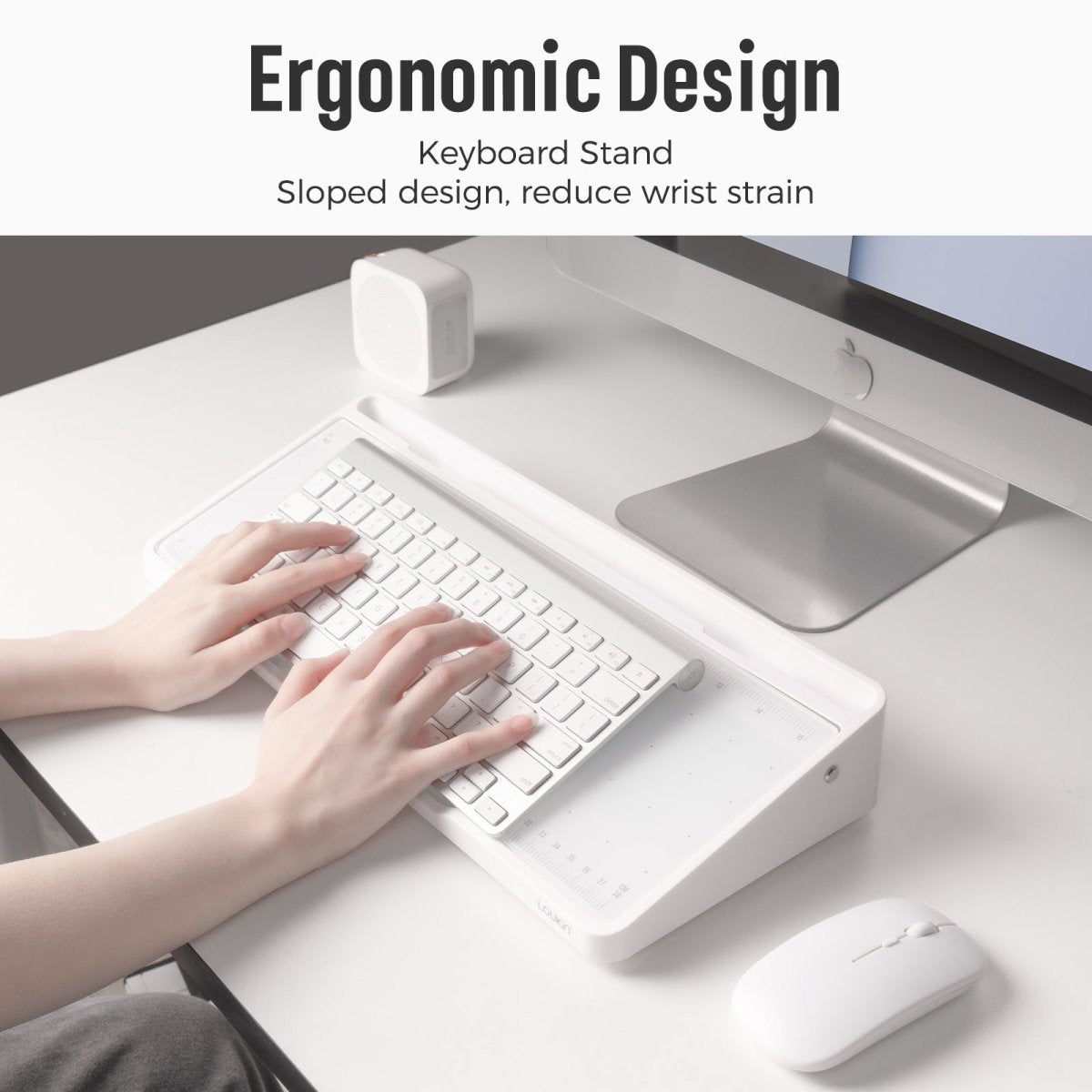 The Loukin Glass Desktop Whiteboard (W1701K) highlighting its Ergonomic Design as a Keyboard Stand. The image shows a close-up of hands typing on a white keyboard resting on the whiteboard's sloped surface, with the text stating the sloped design helps to reduce wrist strain. The stand is next to a white wireless mouse and computer monitor.