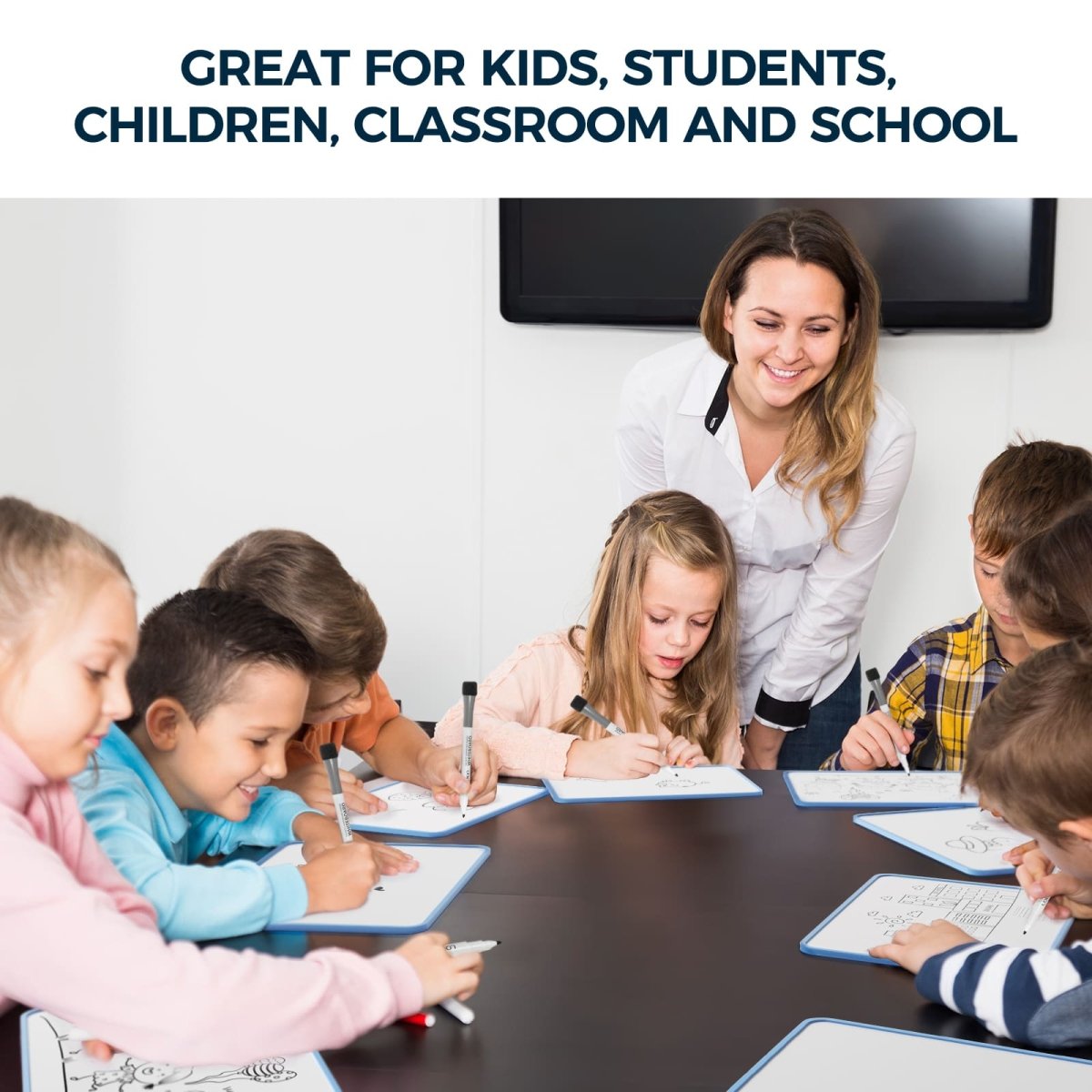 Feature image for the Loukin Seamless Frame Kid Dry Erase Lapboard (W1802K), highlighting its ideal use in educational settings with the text: "GREAT FOR KIDS, STUDENTS, CHILDREN, CLASSROOM AND SCHOOL." The photo shows a teacher smiling and supervising a group of young students sitting around a table, each actively using a lapboard and dry erase marker for individual or group work.